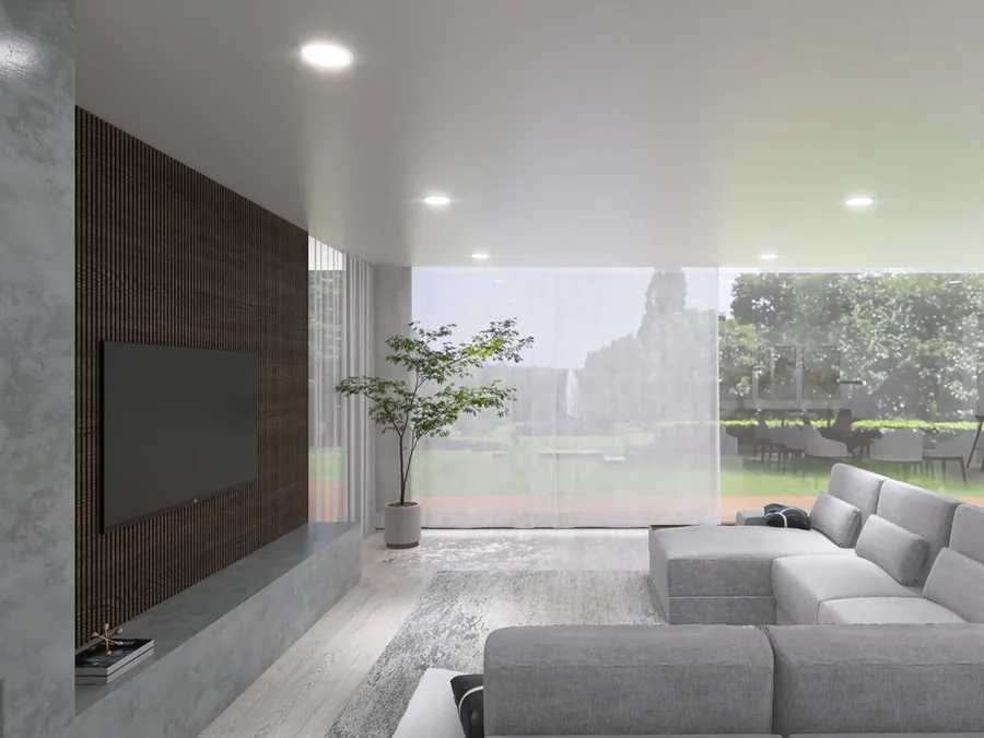 Sala das Casas da Quinta, com o painel ripado e a televisão à esquerda, o sofá virado para o vão envidraçado e o jardim