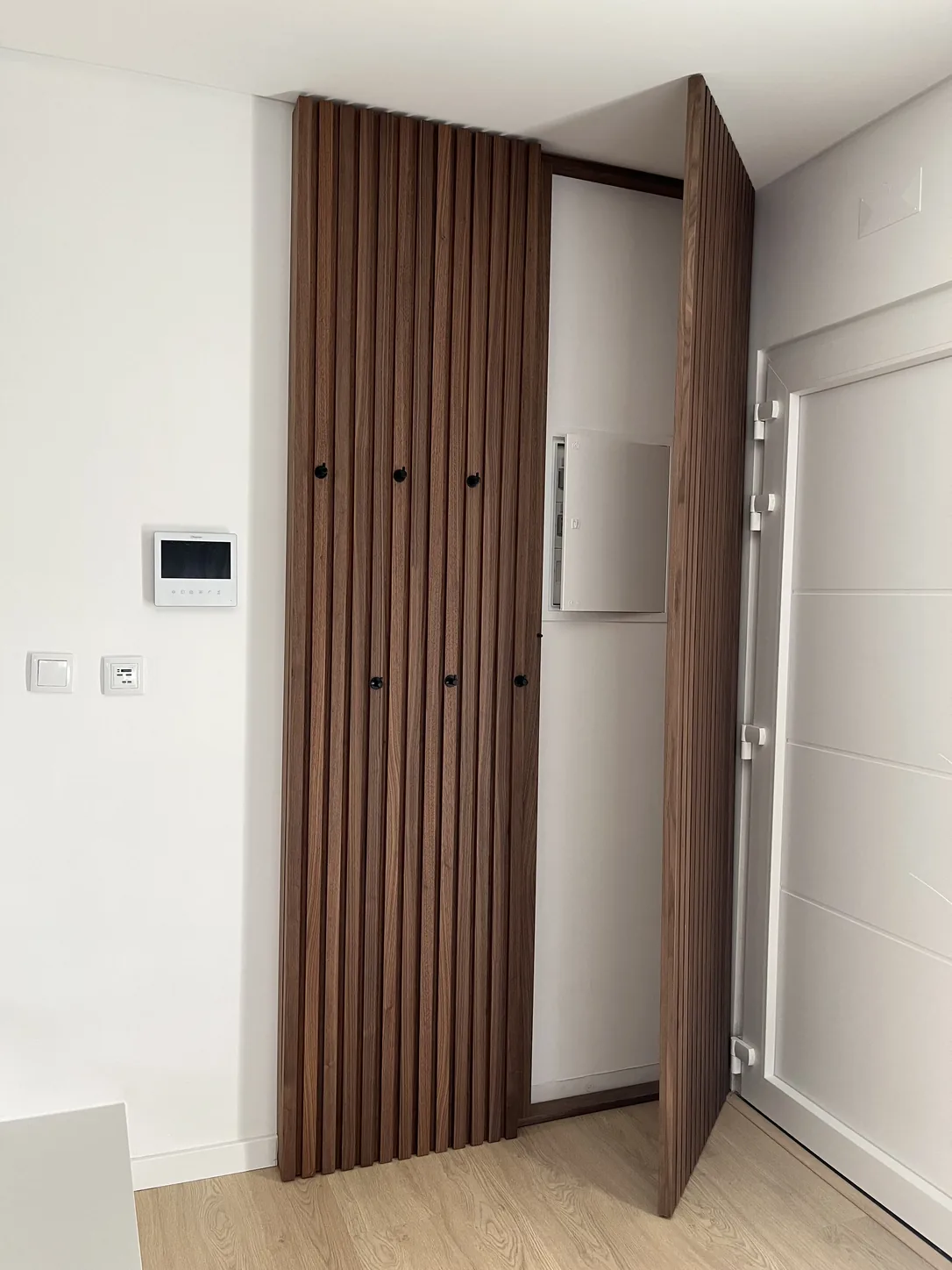 O mesmo painel aberto, a mostrar o armário técnico e o quadro elétrico por trás